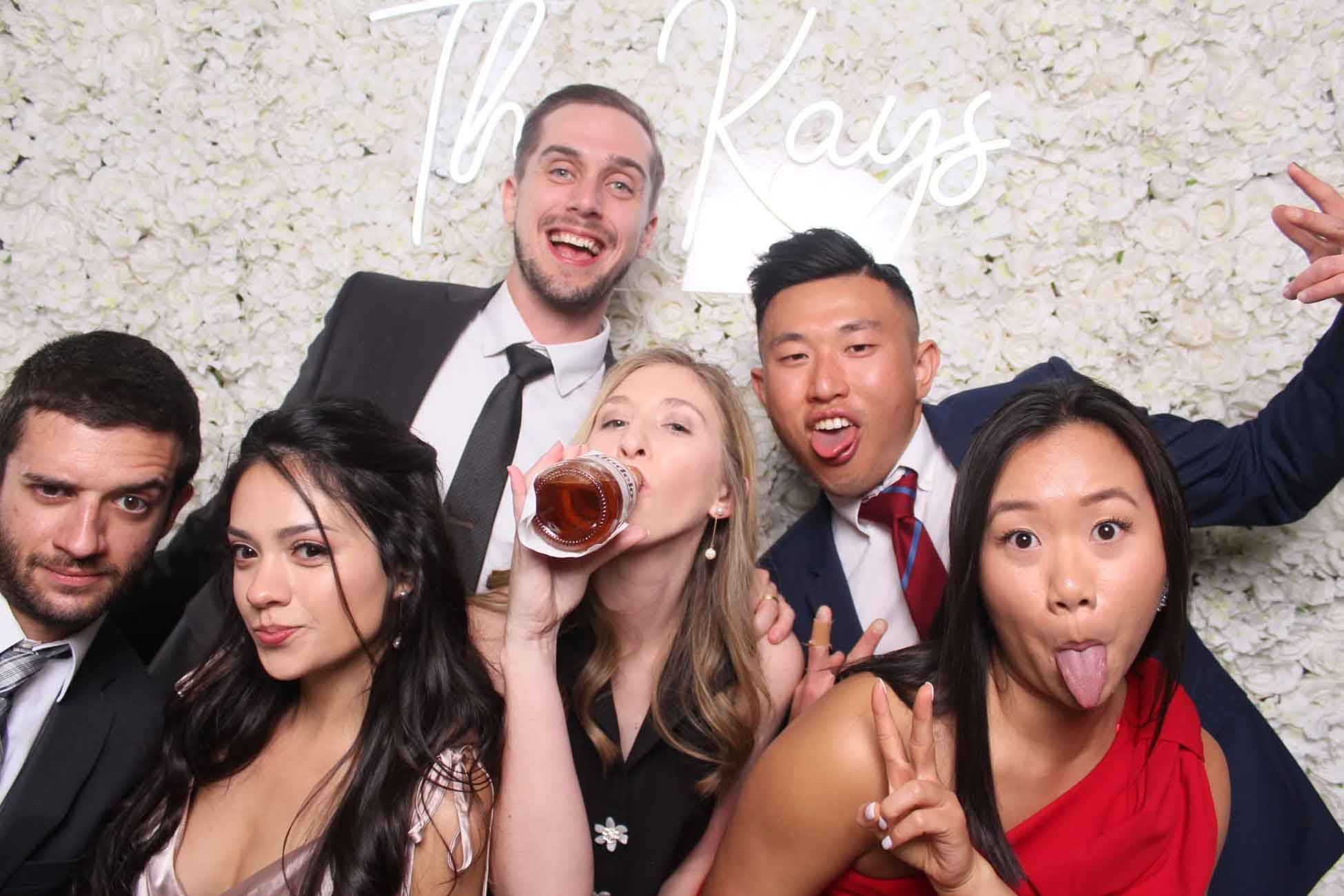 Wedding guests in front of a white flower wall