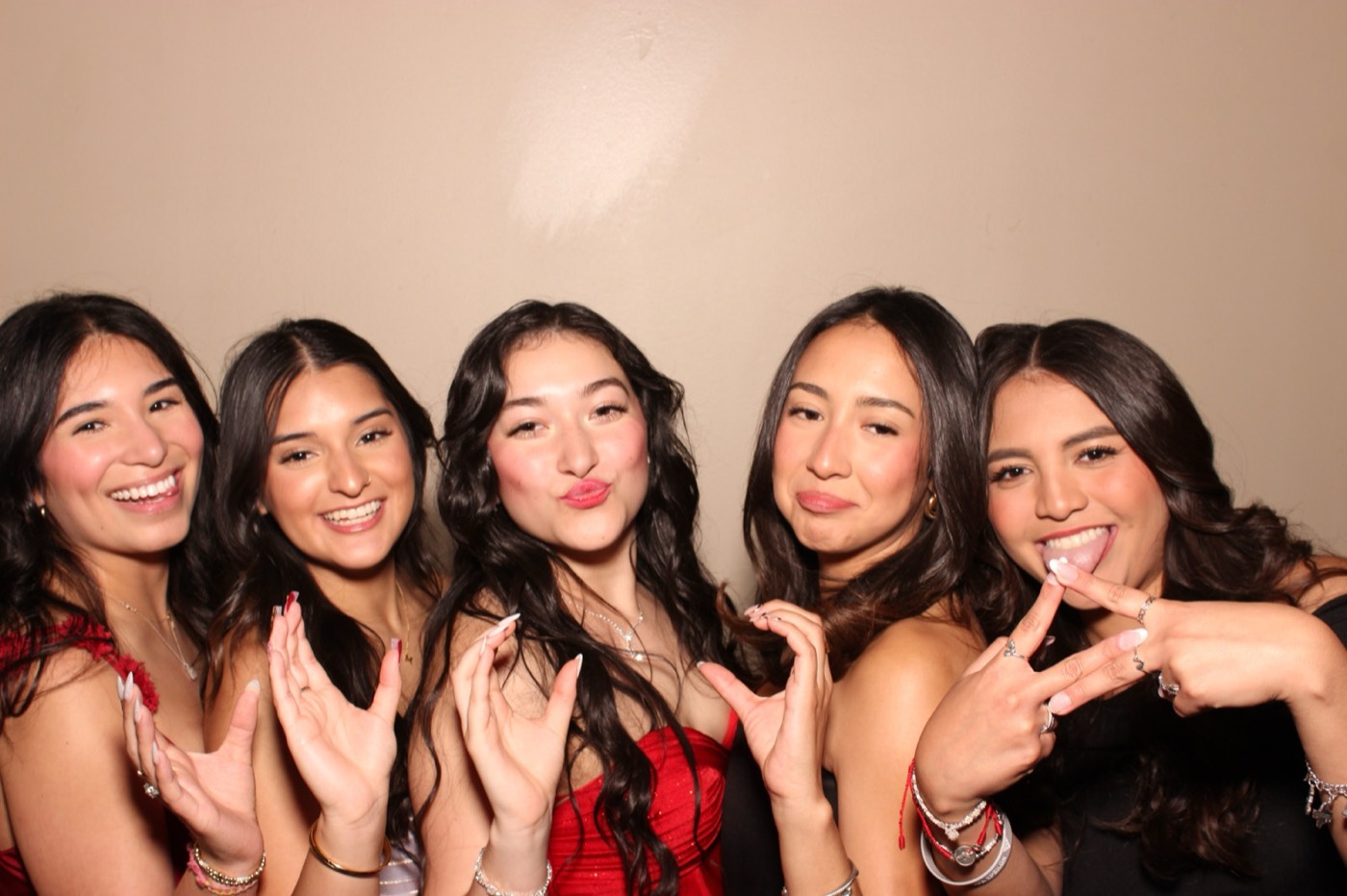 Five friends in formal dresses posing together at a formal dance in San Antonio
