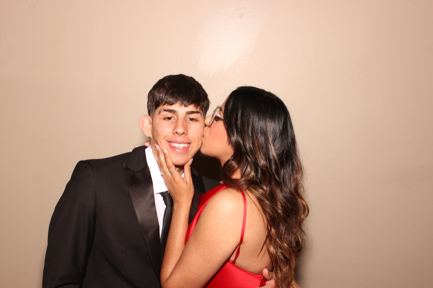 A girl kissing her date on the cheek at a formal dance in San Antonio