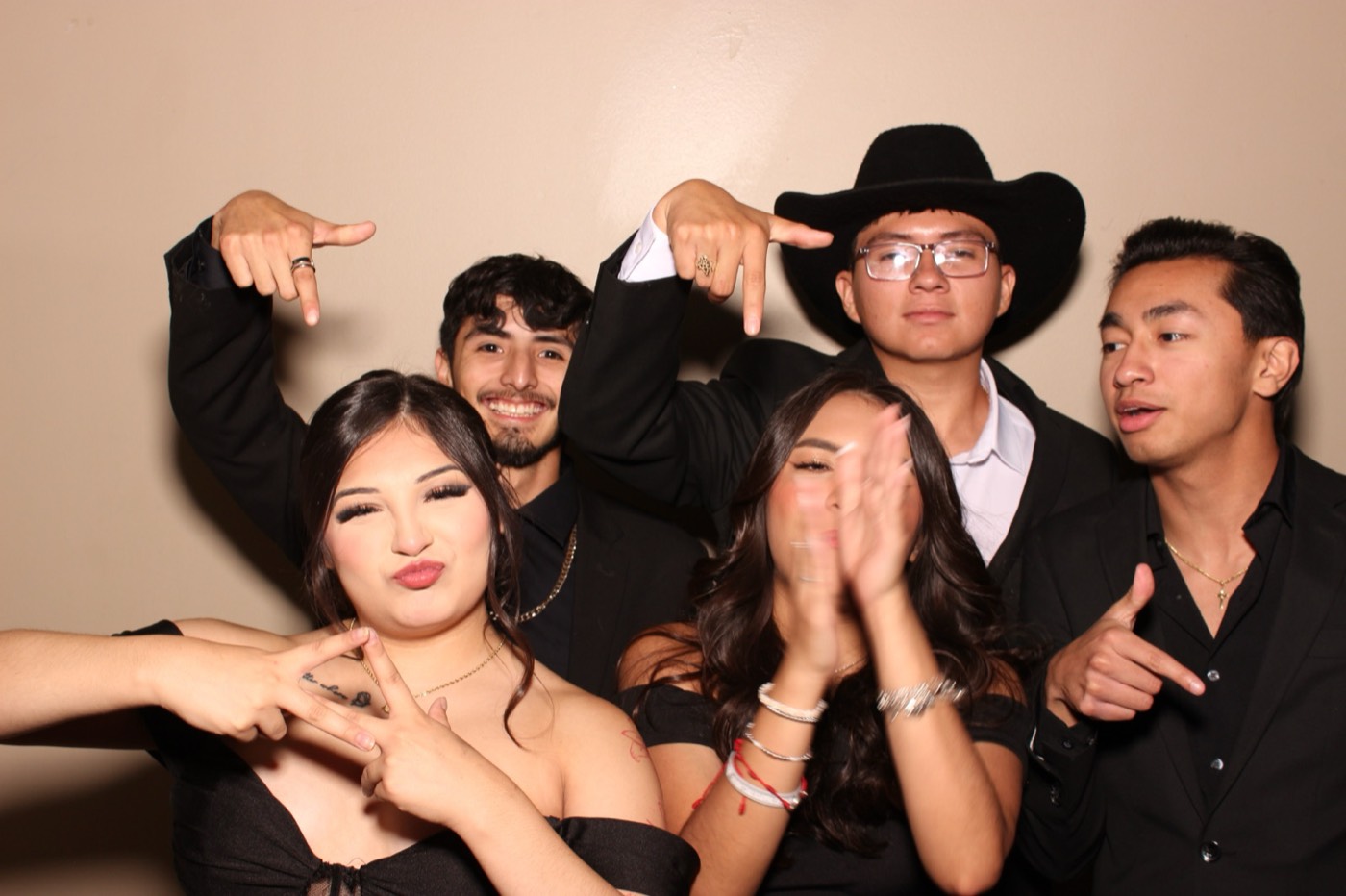 Friends posing with a guest in a cowboy hat at a formal dance in San Antonio