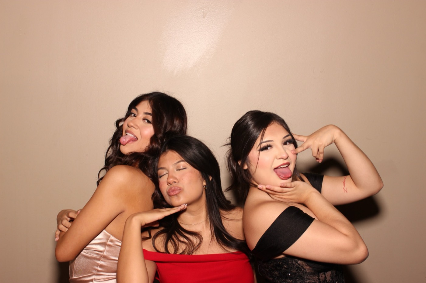 Three friends posing in their dresses at a formal dance in San Antonio