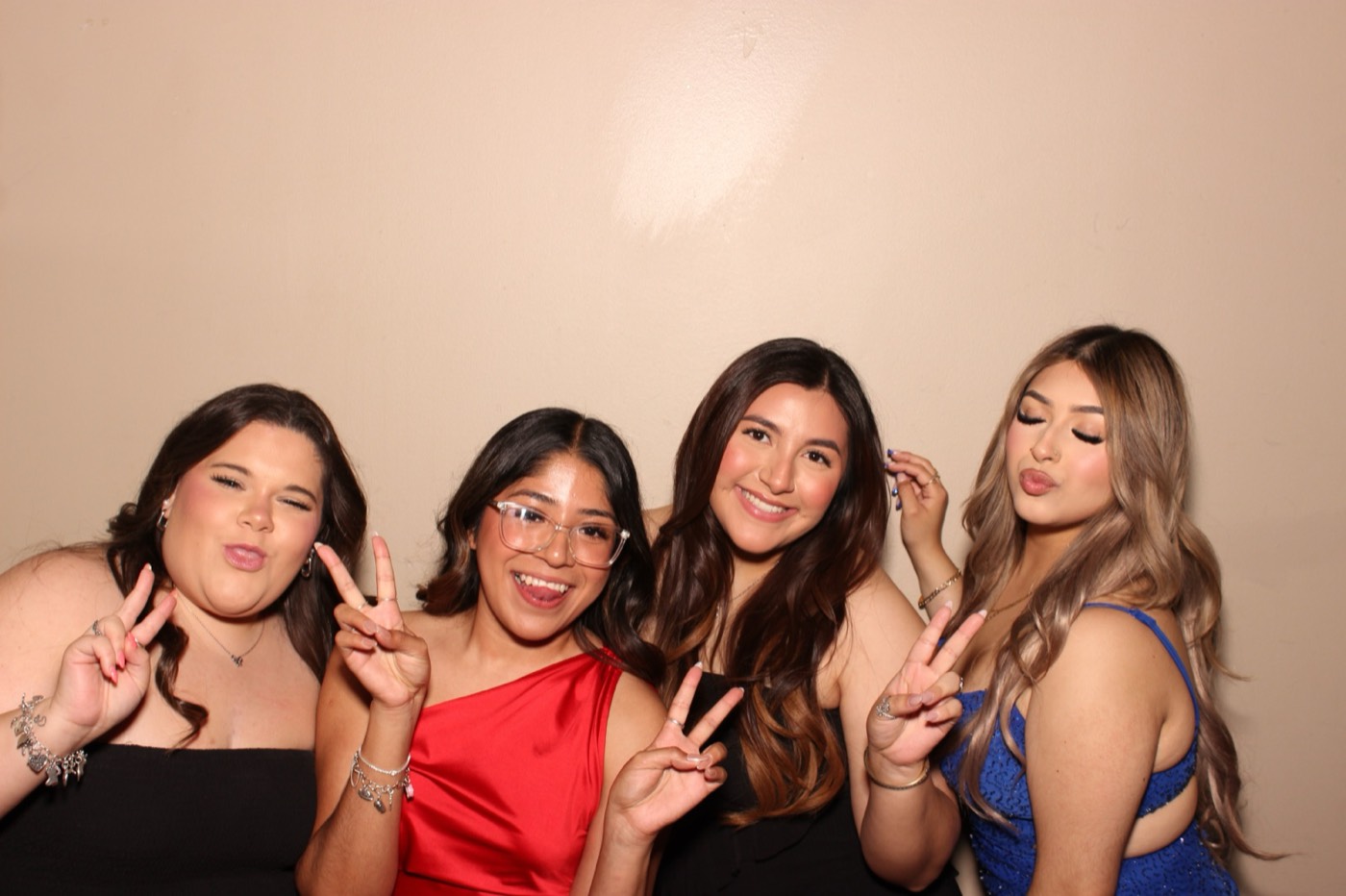 Four friends throwing peace signs at a formal dance in San Antonio