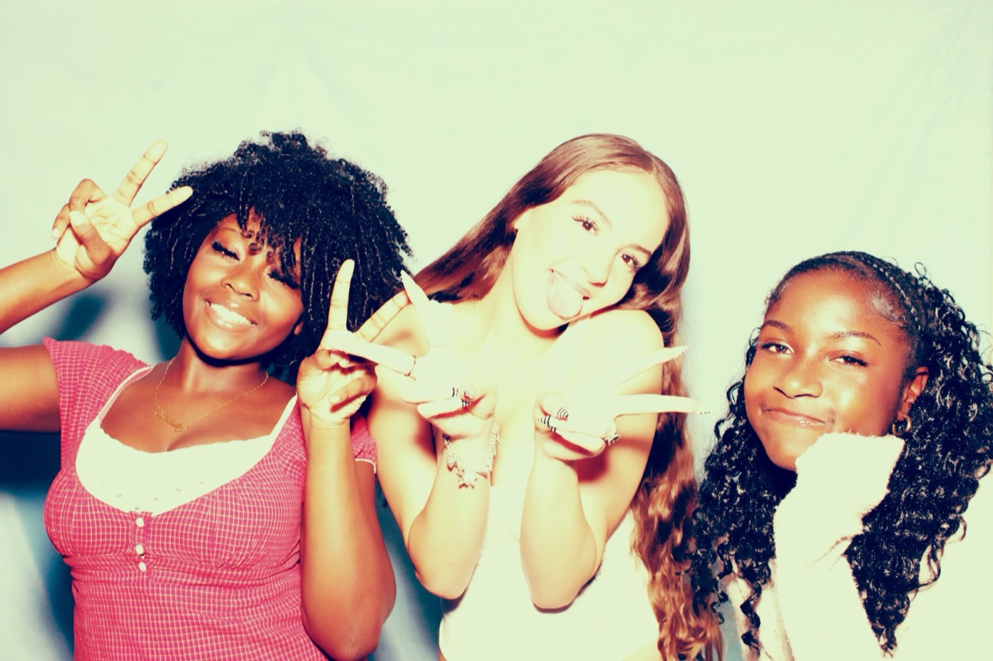 Three friends throwing peace signs at a house party in San Antonio