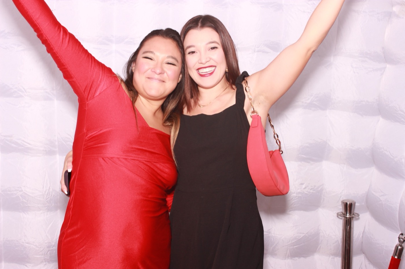 A guest in a red dress celebrating with an arm in the air at a quince party in San Antonio