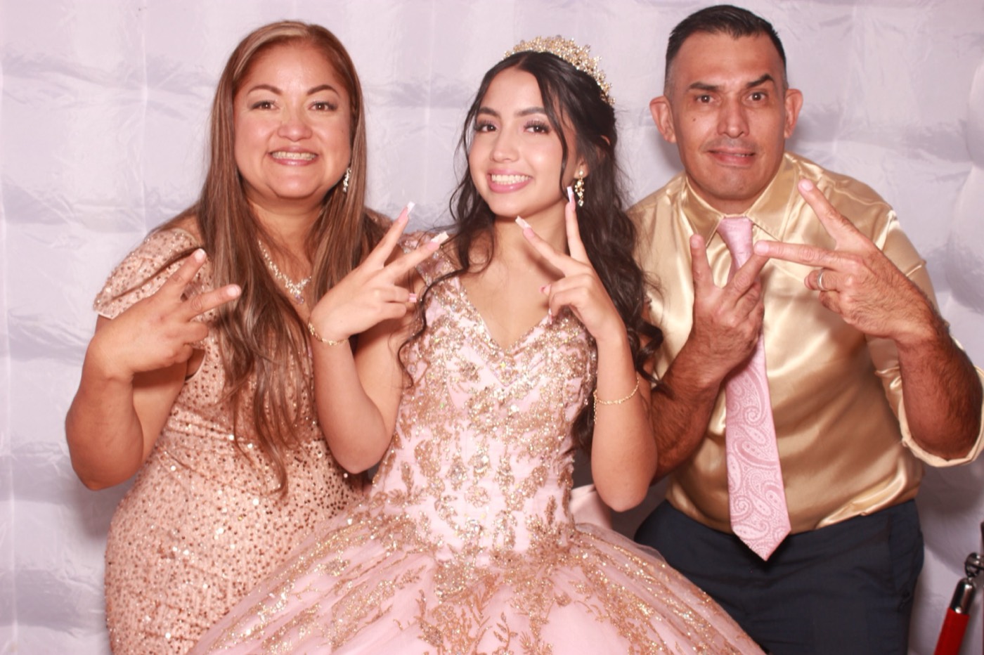 A quinceañera posing with her parents at a quince party in San Antonio