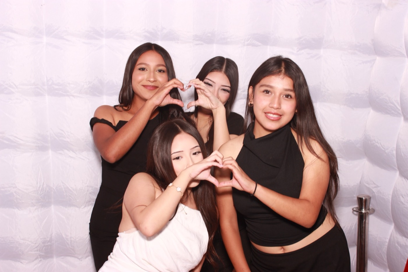 Friends making heart hands at a quince party in San Antonio