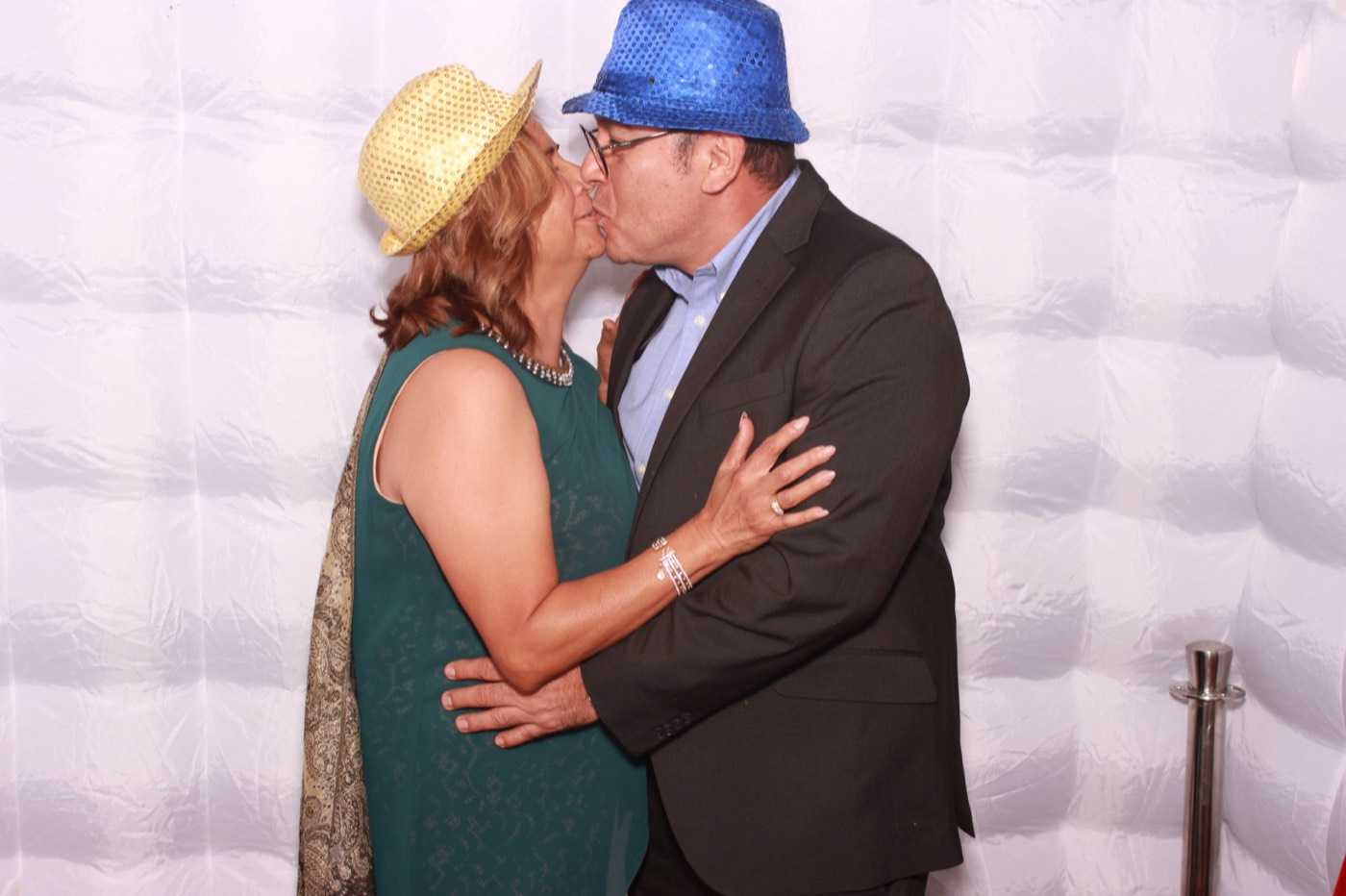 A couple sharing a kiss in party hats at a quince party in San Antonio