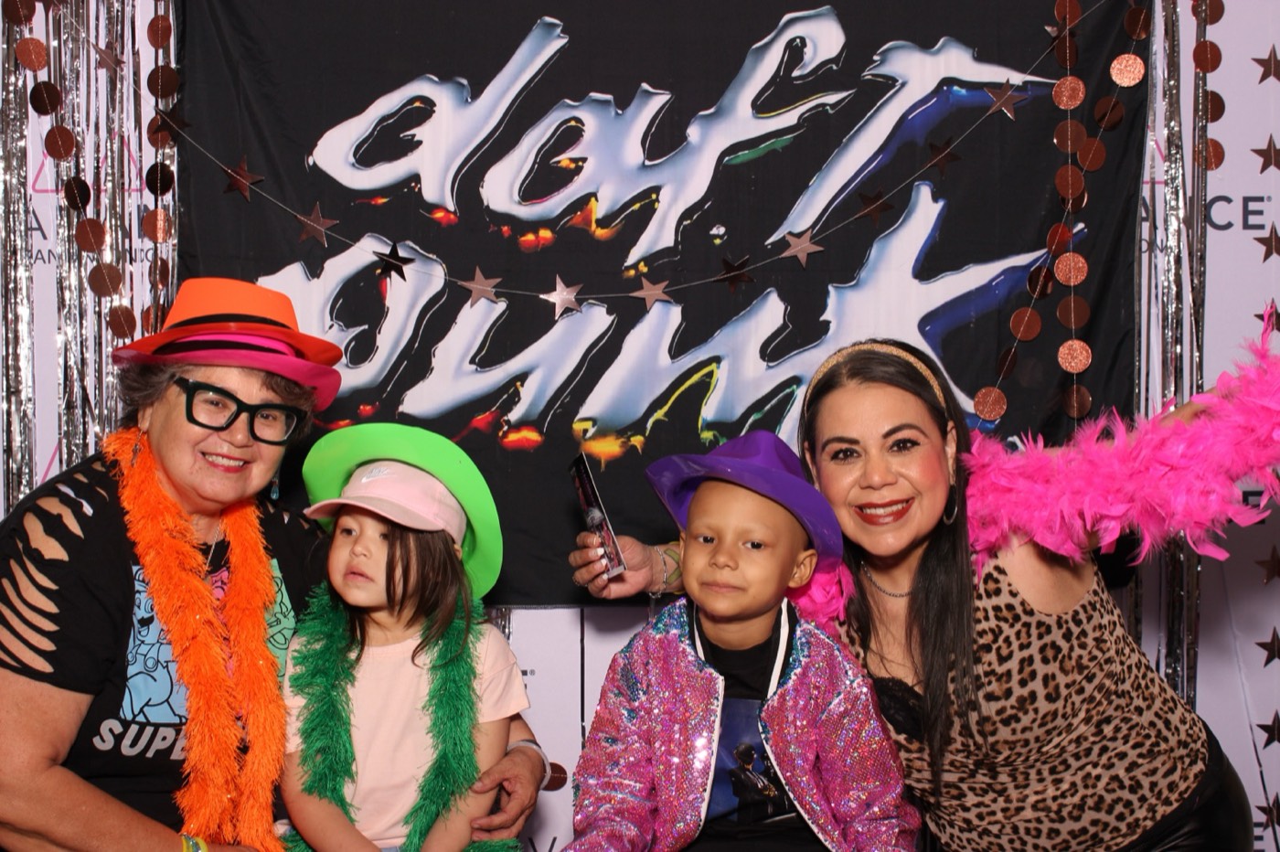 Grandparents and kids in colorful party hats and boas at a Daft Punk themed birthday party