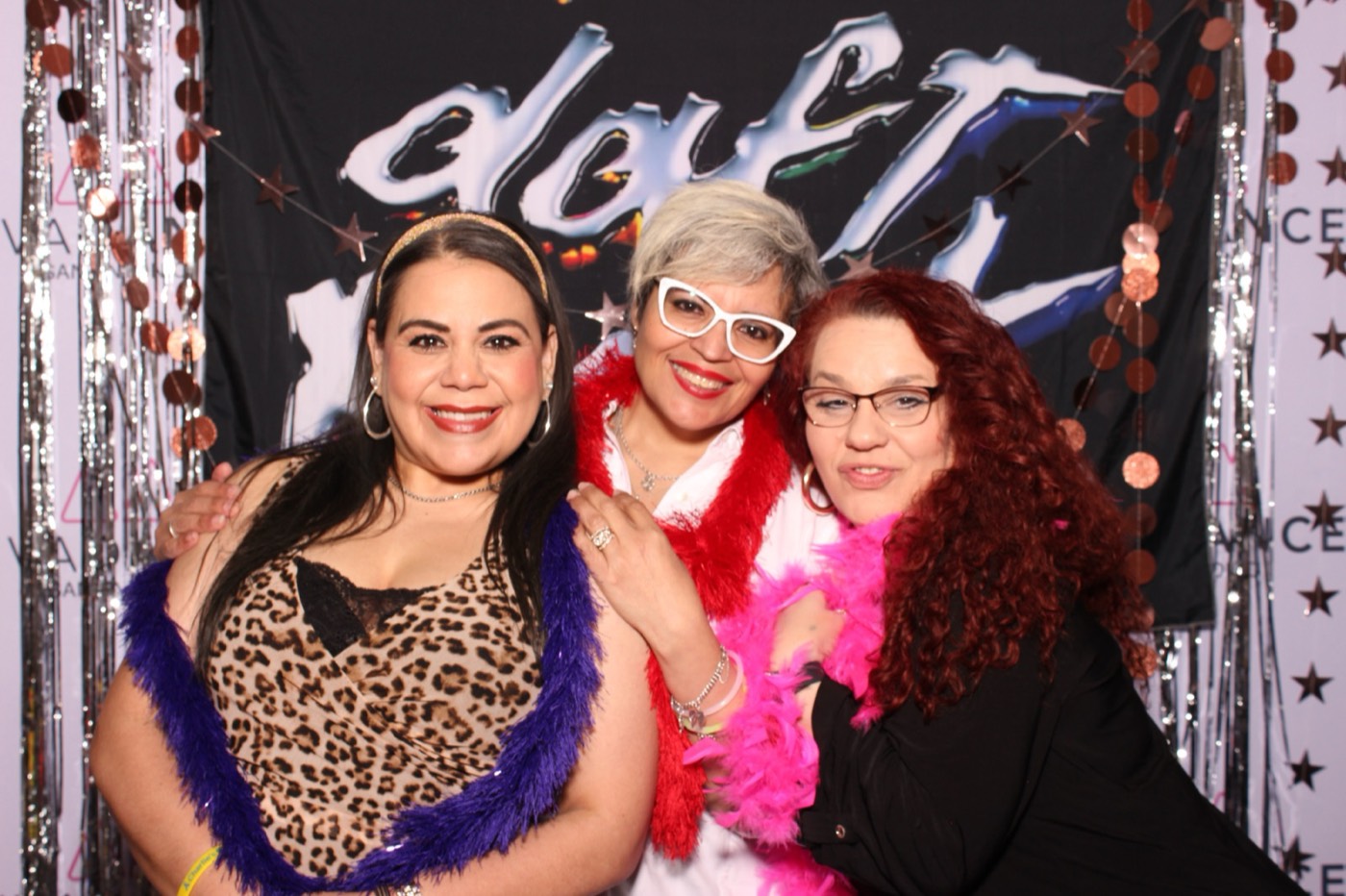 Three friends in feather boas and fun glasses at a Daft Punk themed birthday party