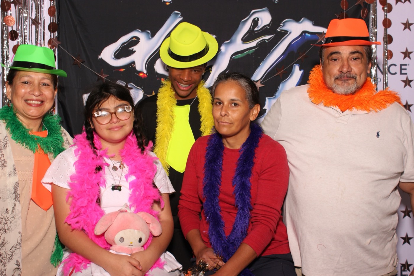 A family group in colorful boas at a Daft Punk themed birthday party