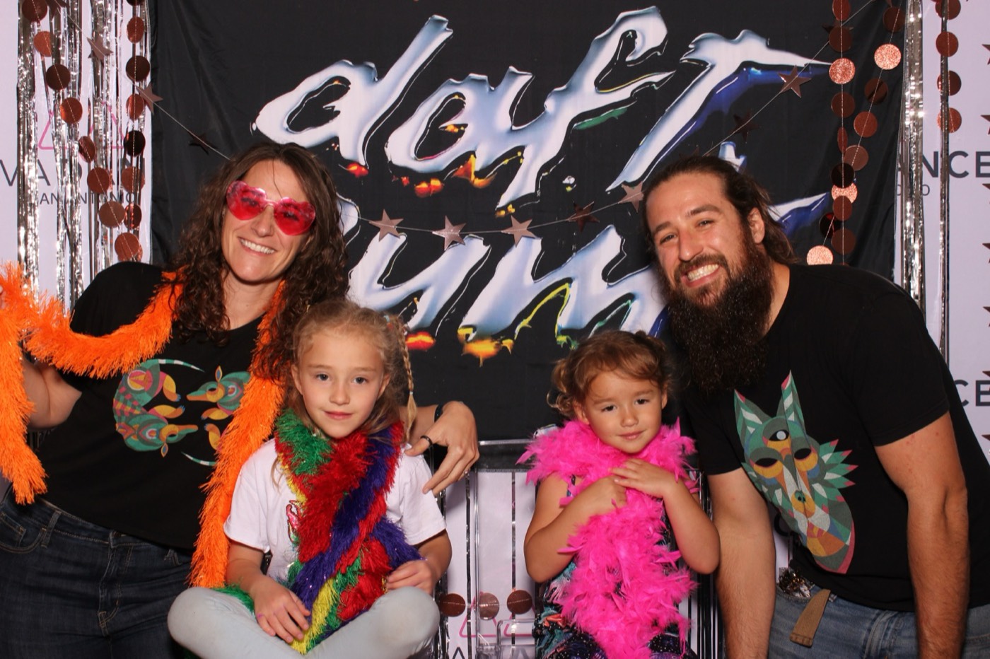A family with two little girls in boas at a Daft Punk themed birthday party