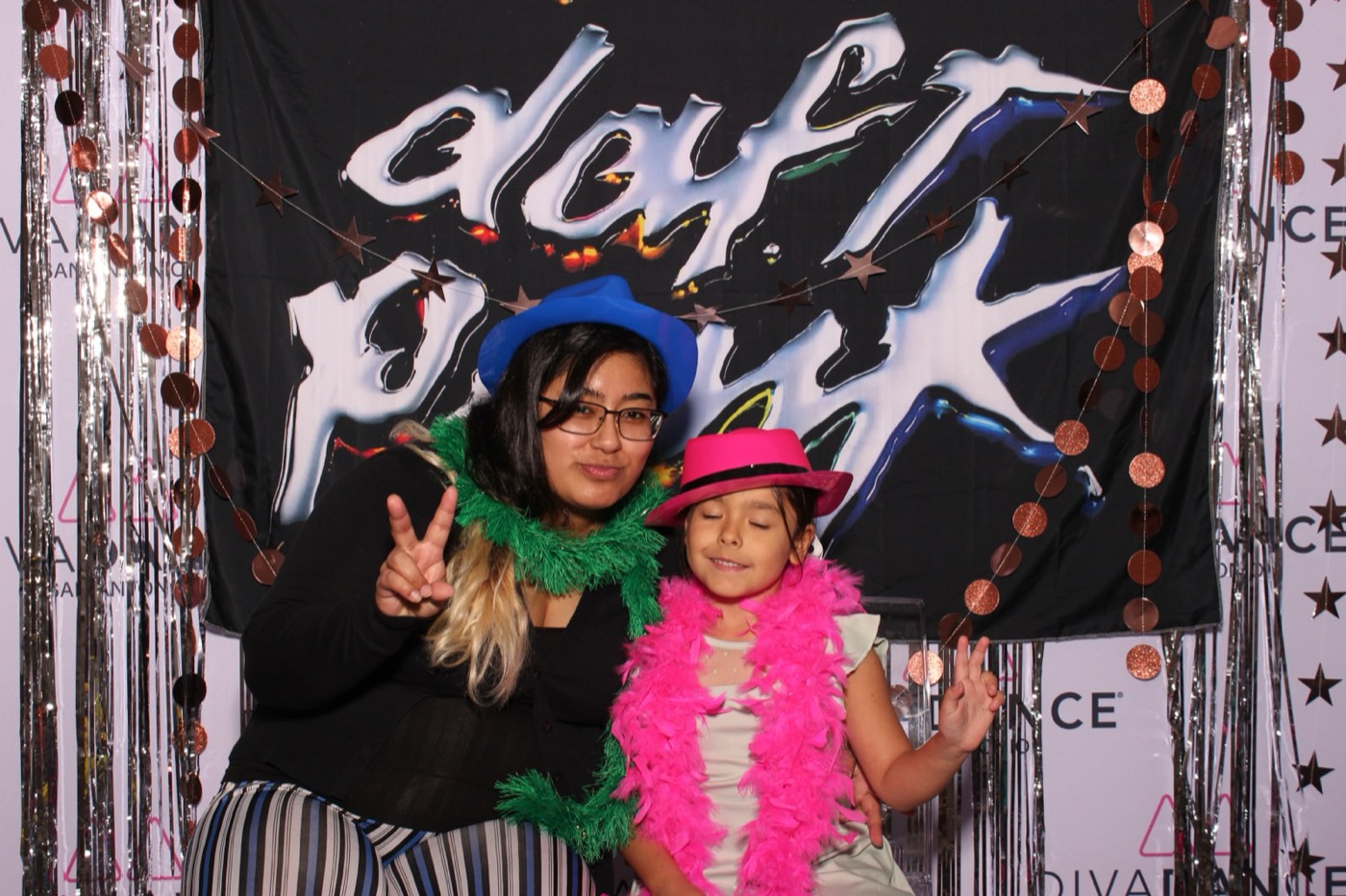 A guest and a little girl in feather boas at a Daft Punk themed birthday party