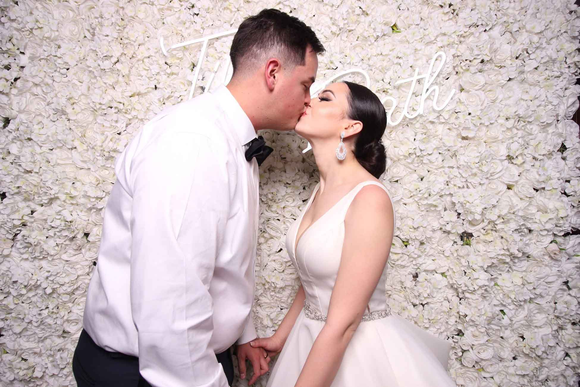 Bride and groom sharing a kiss in a wedding photo booth by Mr Booth in San Antonio.